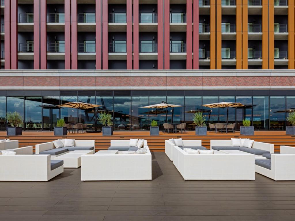 a row of white couches in front of a building at LIBER HOTEL Osaka in Osaka