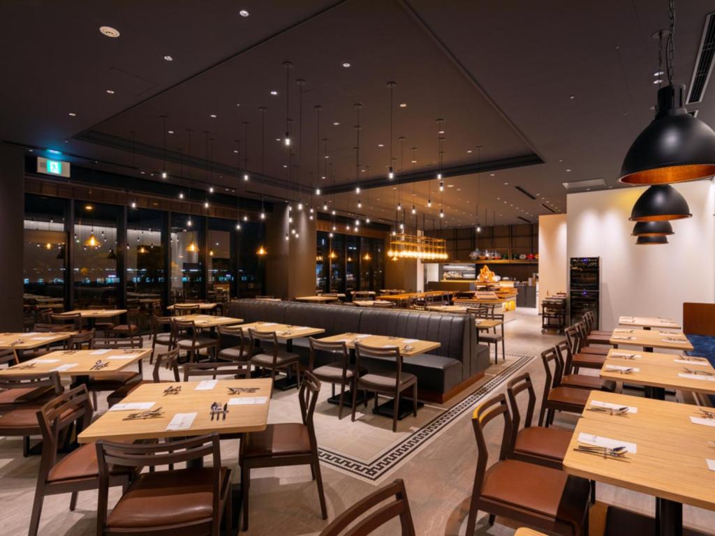 a dining room with wooden tables and chairs at LIBER HOTEL Osaka in Osaka