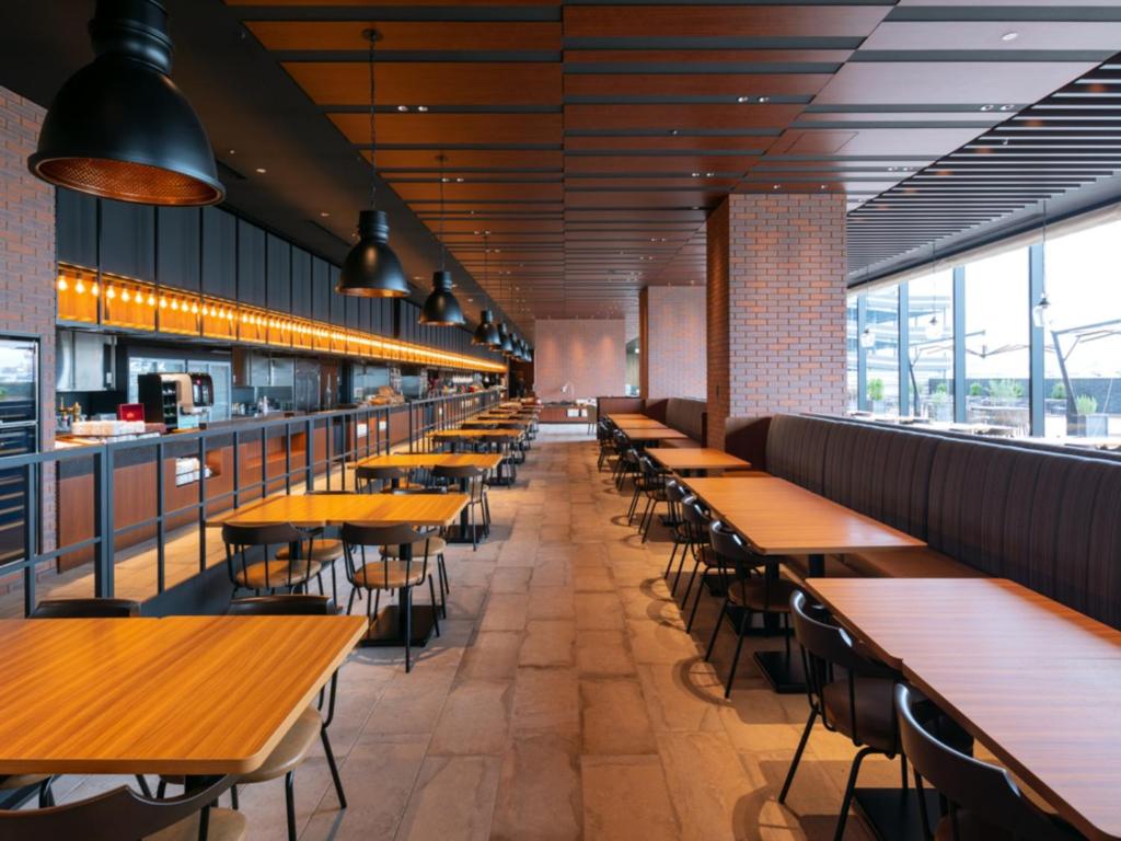 a row of tables and chairs in a restaurant at LIBER HOTEL Osaka in Osaka