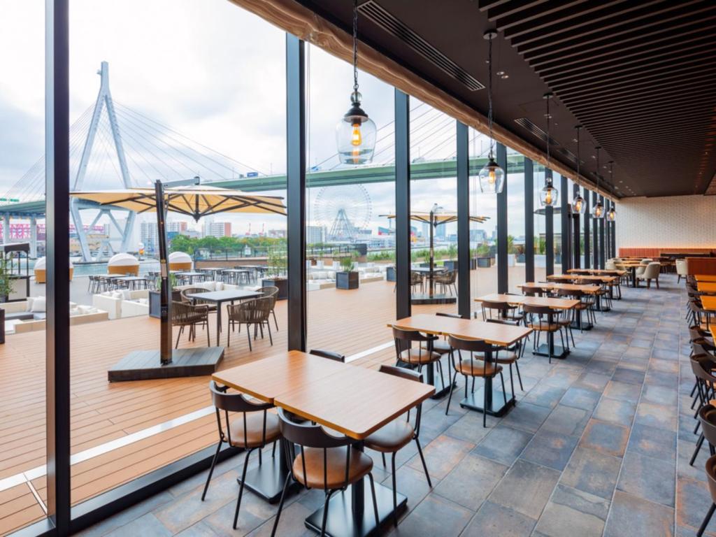 a row of tables and chairs on the deck of a restaurant at LIBER HOTEL Osaka in Osaka