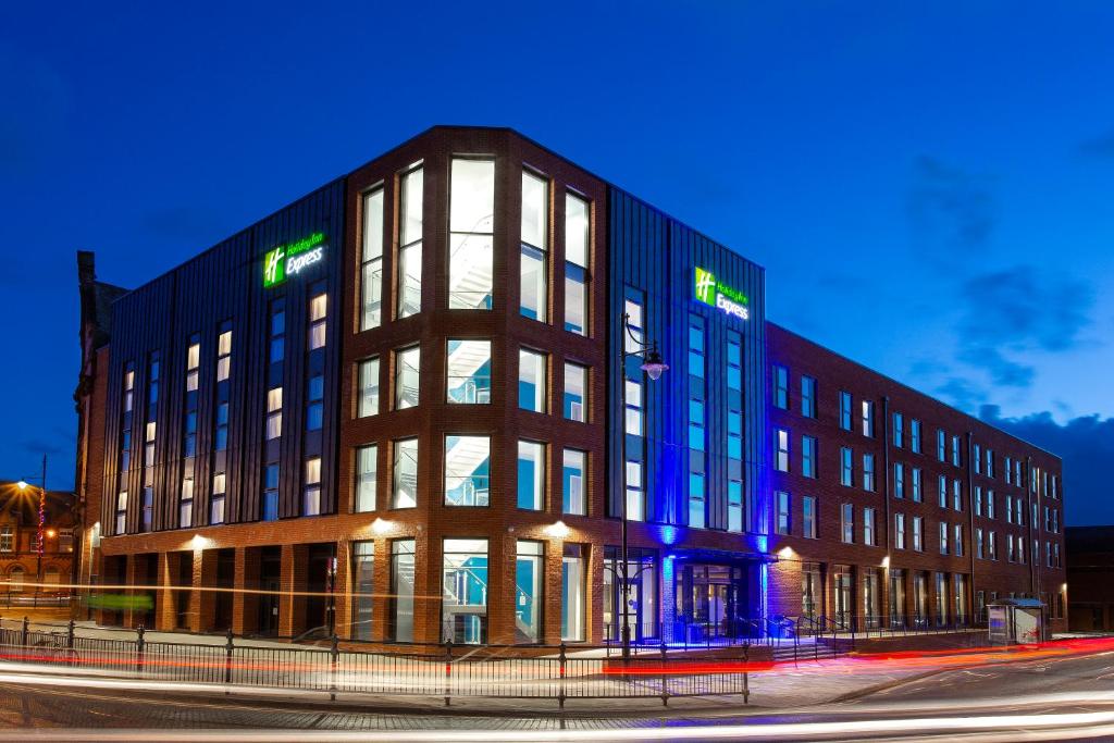 un gran edificio con luces azules en el lateral en Holiday Inn Express - Barrow-in-Furness & South Lakes, an IHG Hotel, en Barrow-in-Furness