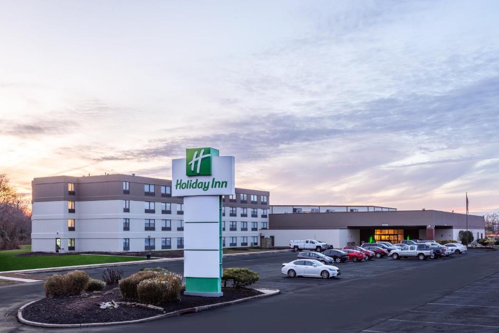 un edificio con un cartel delante de un aparcamiento en Holiday Inn Philadelphia South-Swedesboro, an IHG Hotel, en Swedesboro