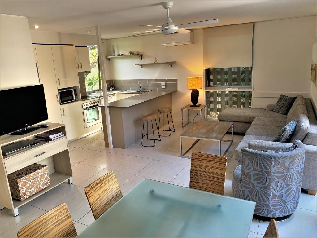 a living room with a couch and a table at The Hastings Beach Houses in Noosa Heads