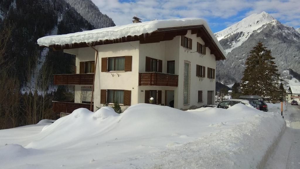 a house covered in snow in front of a mountain at Ferienhaus Willi in Sankt Gallenkirch