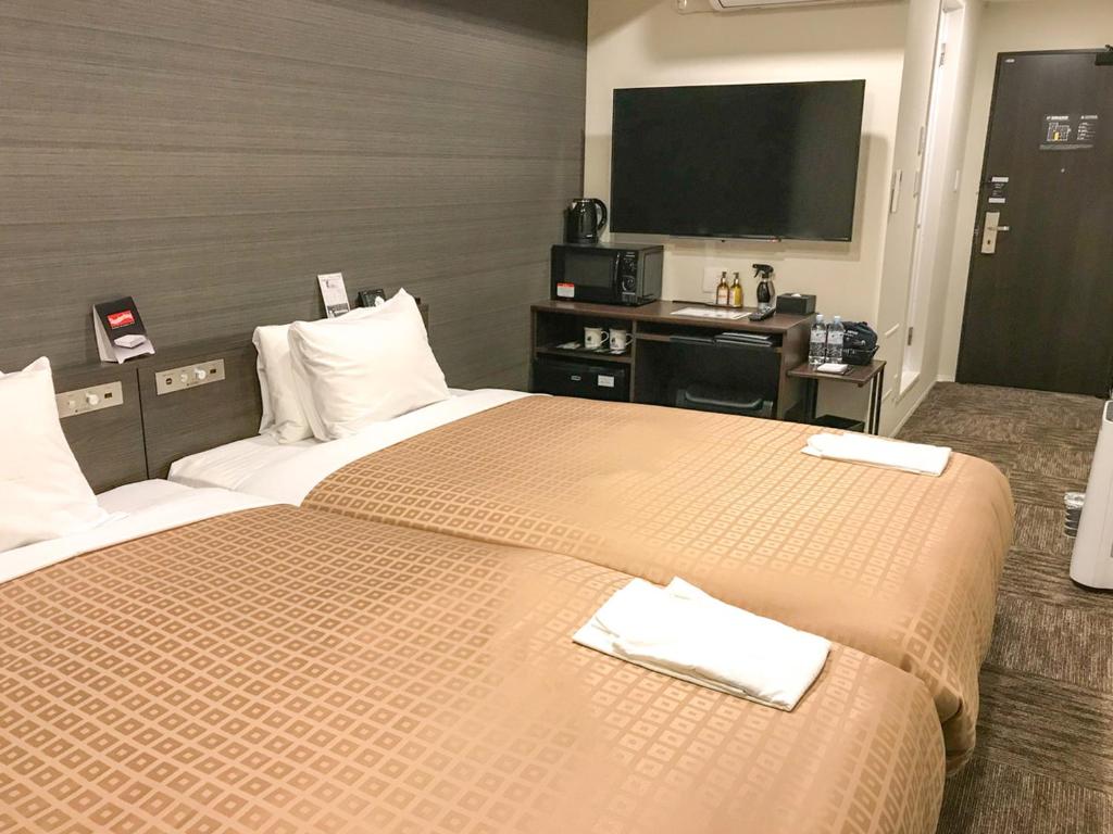 Postel nebo postele na pokoji v ubytování Hotel Livemax Toyama