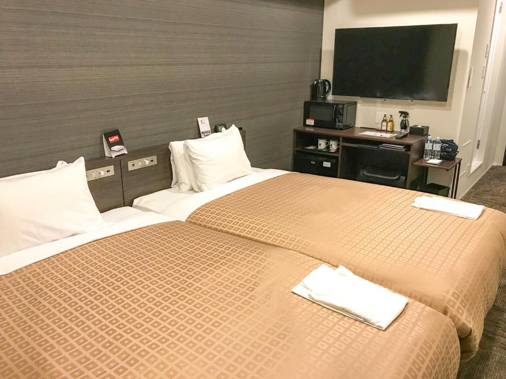 Postel nebo postele na pokoji v ubytování Hotel Livemax Toyama