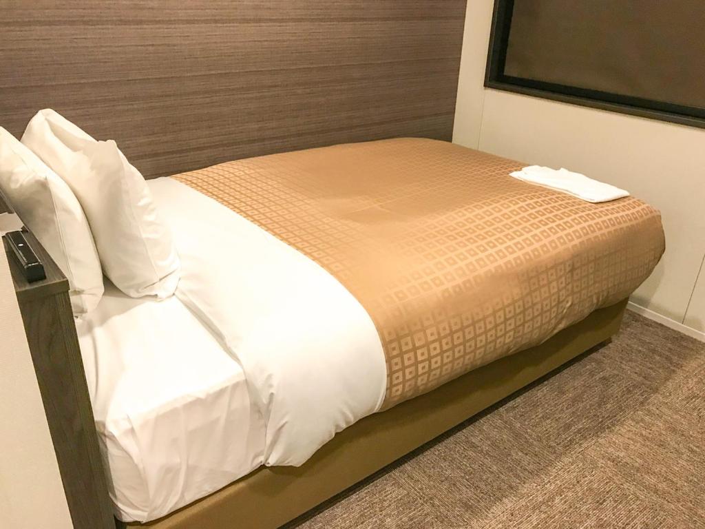 Postel nebo postele na pokoji v ubytování Hotel Livemax Toyama
