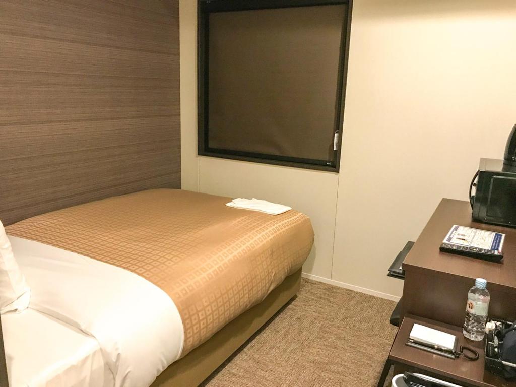 Postel nebo postele na pokoji v ubytování Hotel Livemax Toyama