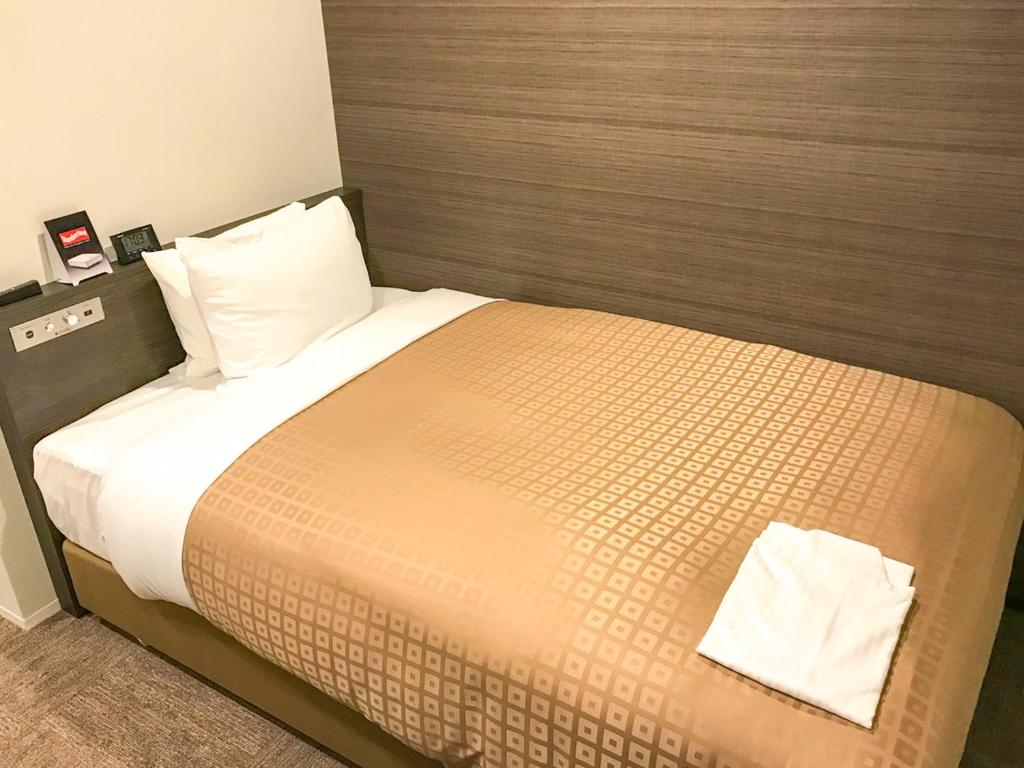 Postel nebo postele na pokoji v ubytování Hotel Livemax Toyama