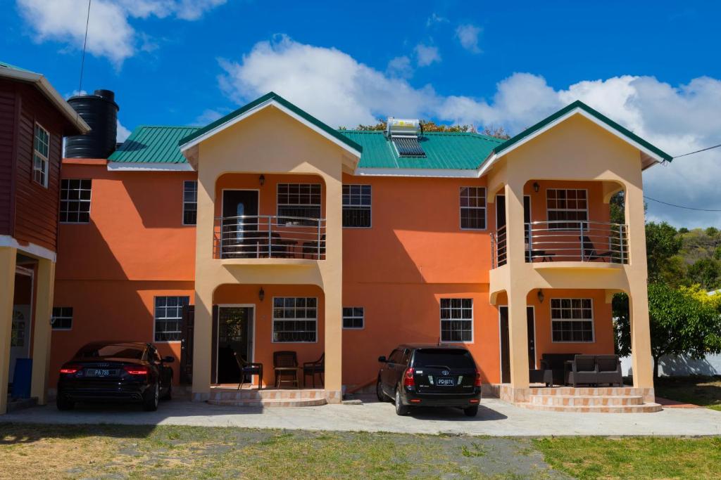 a house with two cars parked in front of it at Jean's ( 1 or 2 B/R ) Condo, Sapphire Estate,Laborie ,St Lucia. Comfort in Style. in Laborie