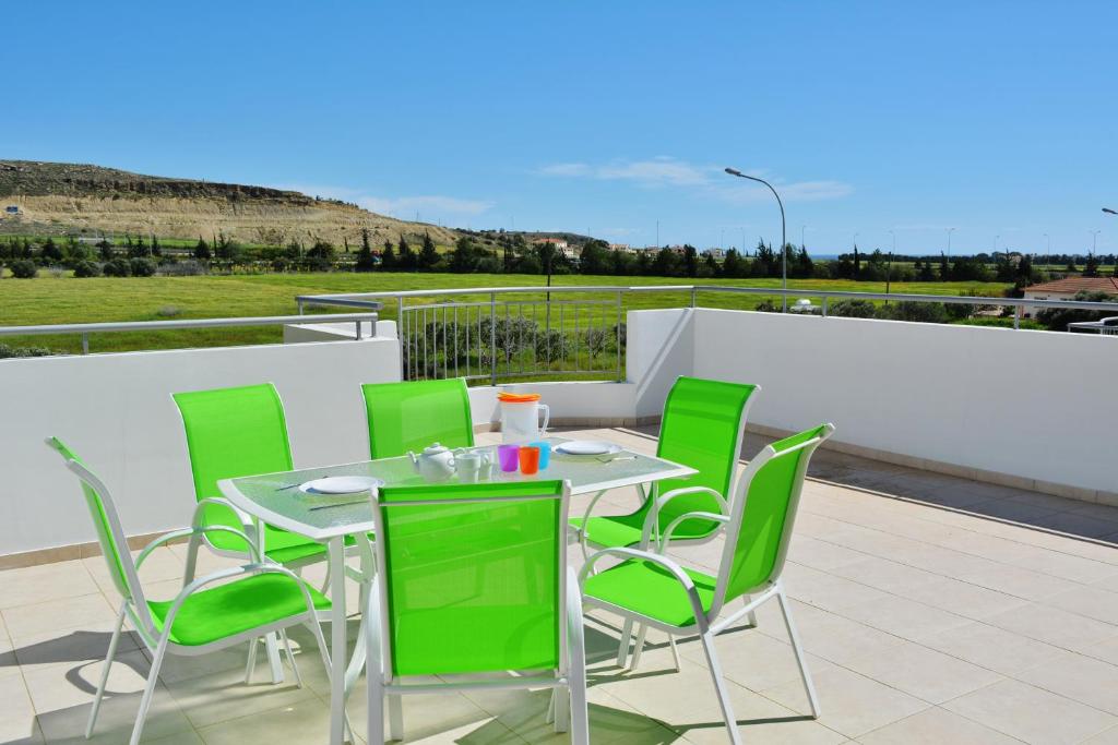 a table and green chairs on a patio at Family Apartment with Terrace in Pyla