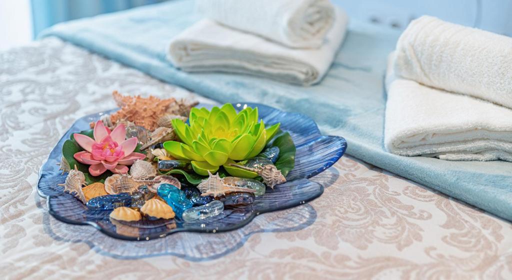 a blue plate with a flower arrangement on a table at Parrot’s House in Lloret de Mar