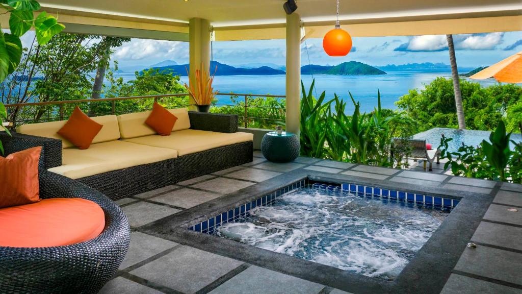 a patio with a hot tub and a couch with a view at Villa Sapphire in Laem Set Beach