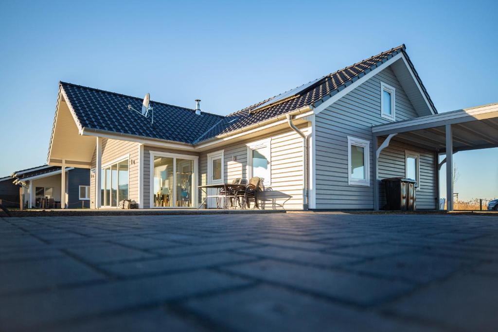 a house with a roof with a patio at Dänisches Blockhaus direkt am Wangermeer in Wangerland