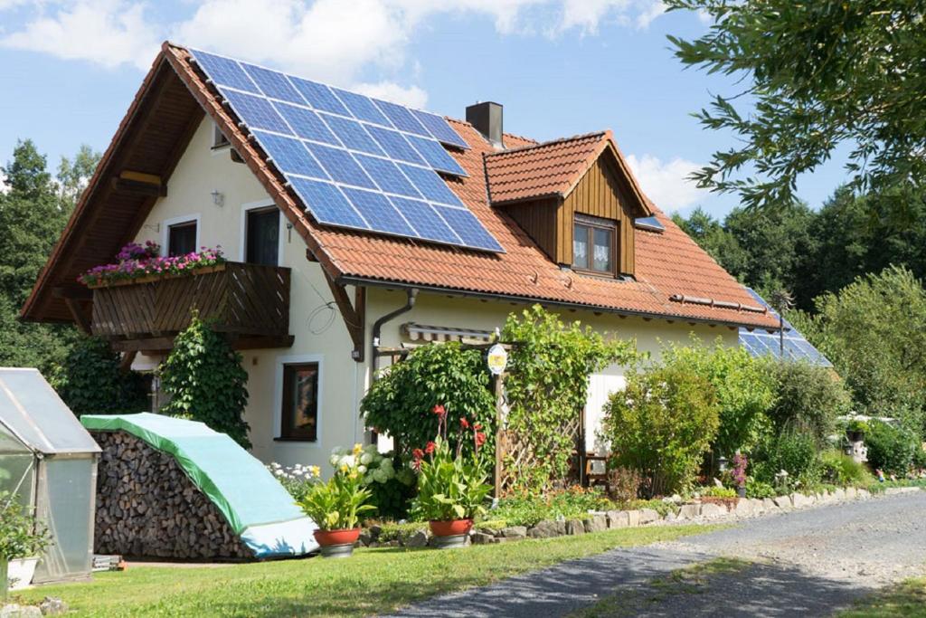 a house with solar panels on the roof at Ferienwohnung Sonja mit Westbalkon in Neualbenreuth