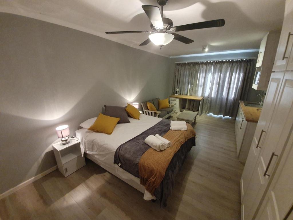 a bedroom with a bed and a ceiling fan at Joey's Rooms in Stellenbosch