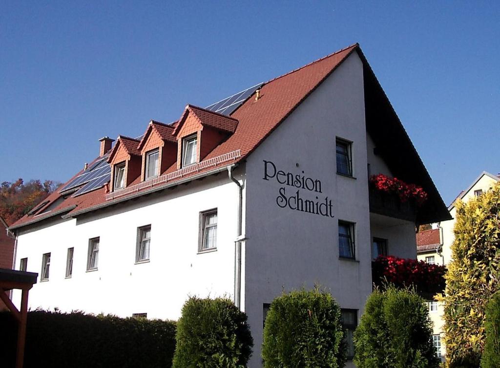 een wit gebouw met een rood dak bij Pension Schmidt in Bad Kösen