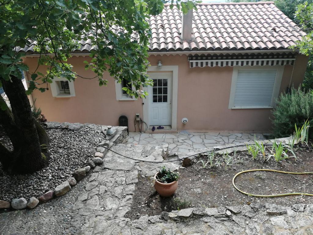 une maison dotée d'un jardin avec une plante en pot en face de celle-ci dans l'établissement "Chênes et Romarins", Calme, Ombrage, Nature, à Bagnols-sur-Cèze