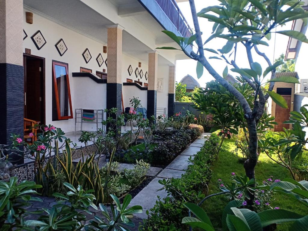 a garden in front of a building with plants at Dwiki Putra Home Stay in Nusa Lembongan