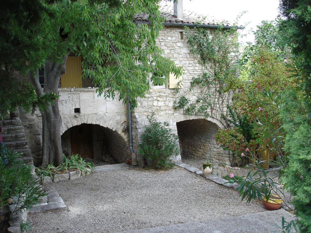 un bâtiment en pierre avec deux entrées sur une cour dans l'établissement Ardèche Ferienwohnung, à Le Garn
