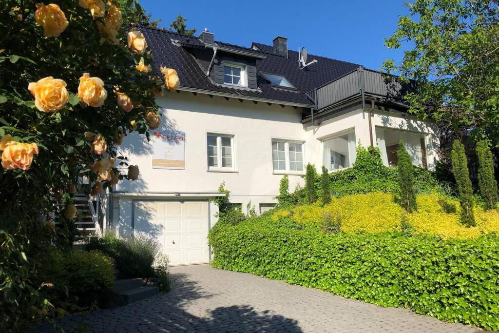 une grande maison blanche avec une allée en face de celle-ci dans l'établissement Schicke Landhauswohnung mit Dachterrasse, à Königswinter