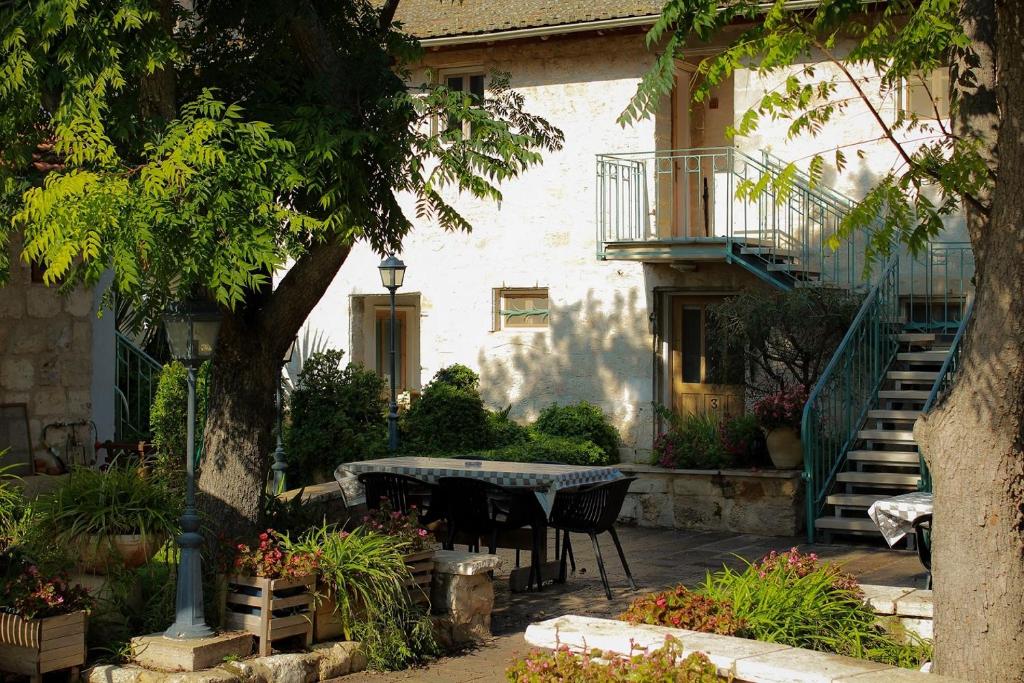 eine Terrasse mit einem Tisch und Stühlen vor einem Gebäude in der Unterkunft Neve Hagar in Bethlehem