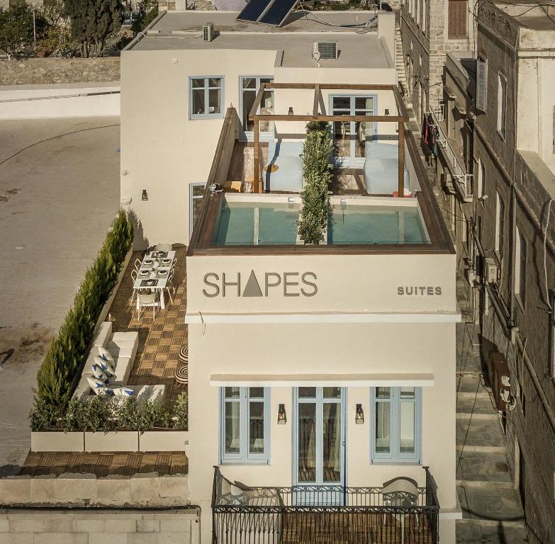 an aerial view of a white building with a sign that reads shapes at Shapes Luxury Suites in Ermoupoli