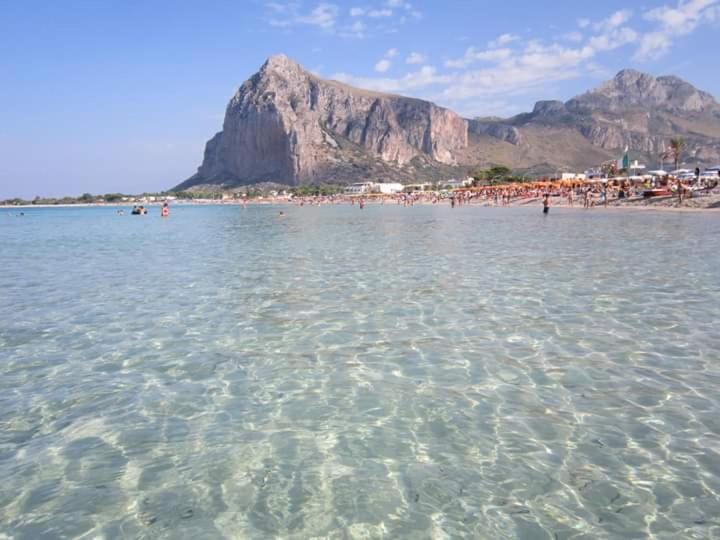a beach with a bunch of people in the water at Villetta a schiera Tety in San Vito lo Capo