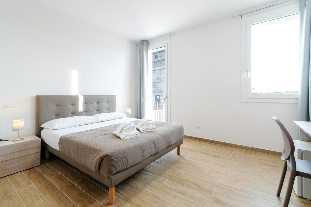 biała sypialnia z dużym łóżkiem i stołem w obiekcie San Vincenzo Rooms Vigonza w mieście Vigonza
