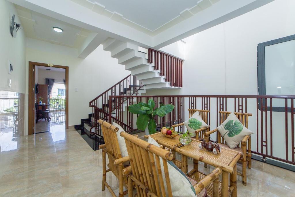 a dining room with a table and chairs and stairs at Coco Village Homestay Hoi An in Hoi An