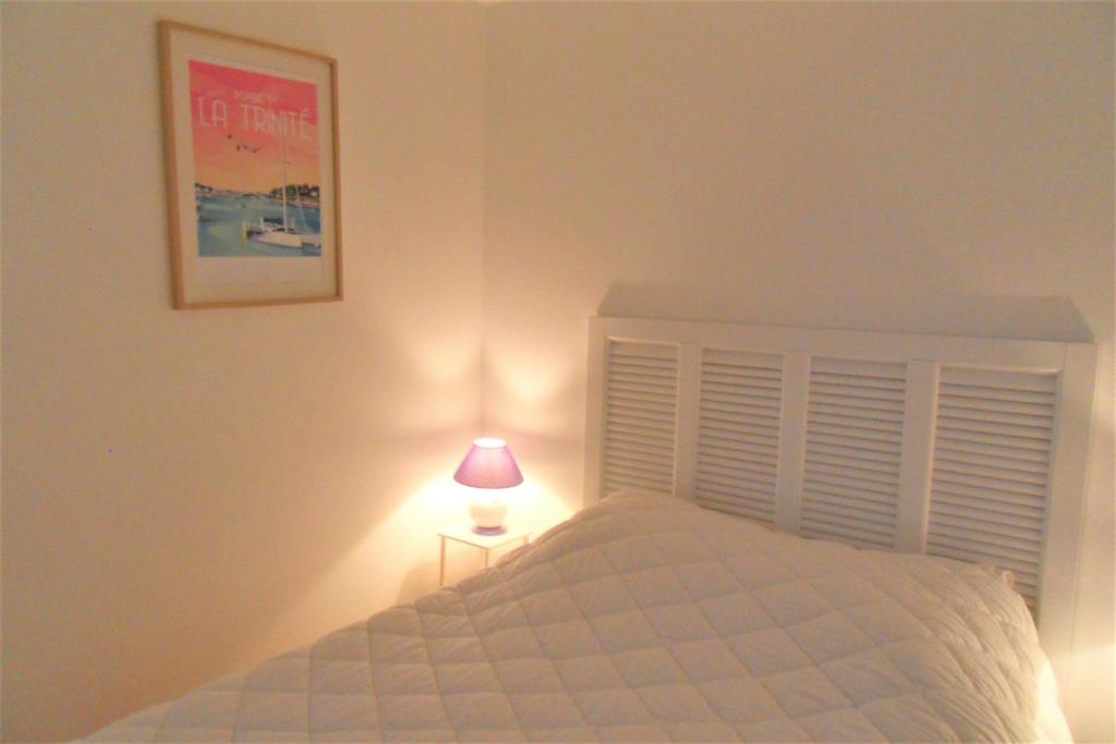 Guidel-PlageにあるApt 6 pers - Magnifique vue mer - Belle terrasse - AZILIZのベッドルーム1室(テーブルの上にランプ付きのベッド1台付)