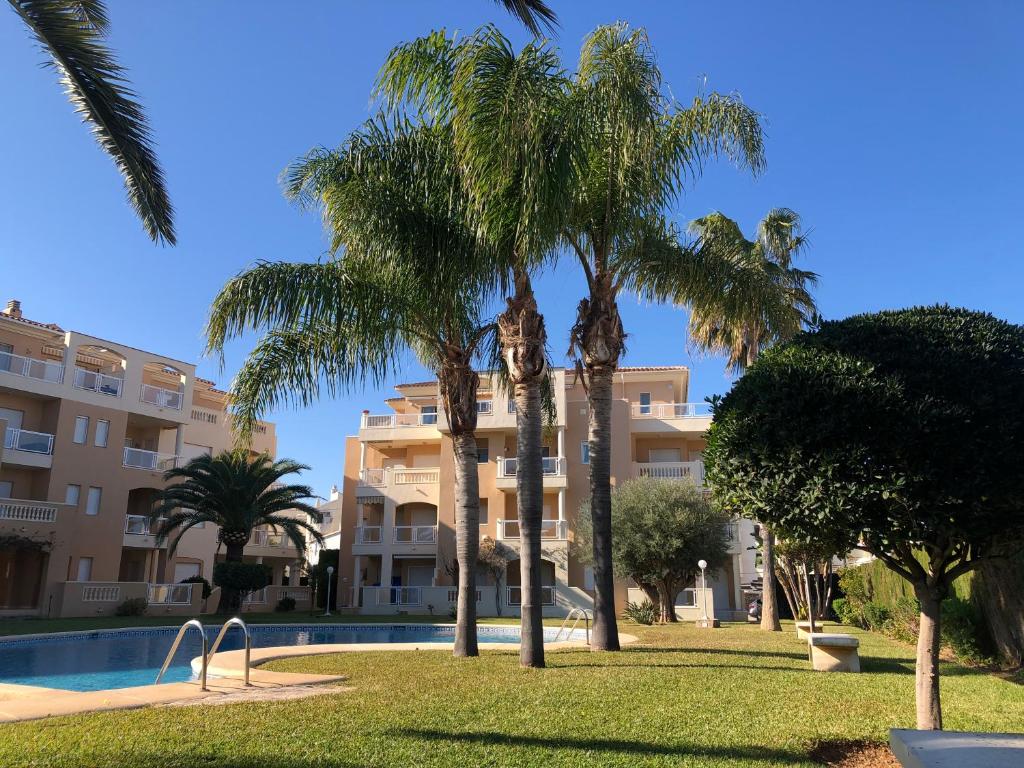 a resort with palm trees in front of a building at Hort 1-Serviden in Denia