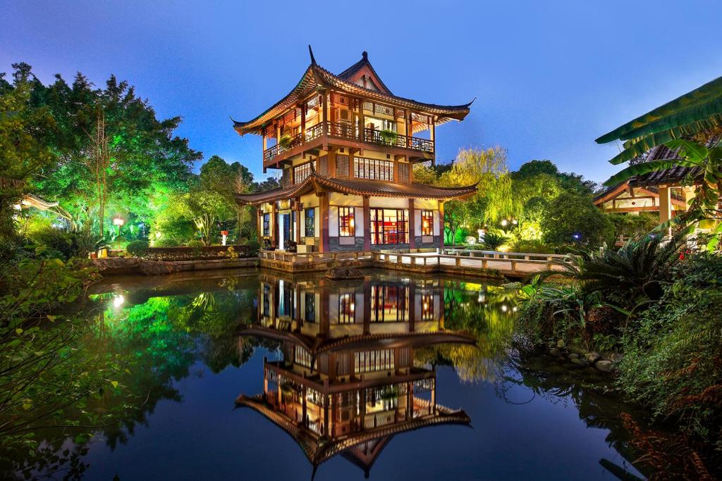 a chinese building on the water at night at Guilin Yi Characteristic Hotel CoLTD in Guilin