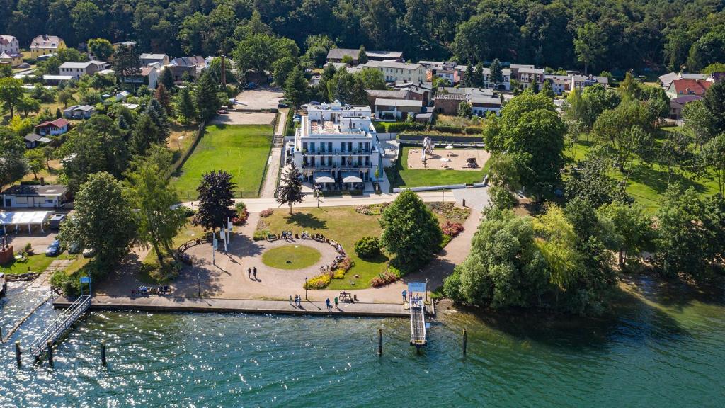 an aerial view of a large blue building next to the water at Fontane Hotel in Schorfheide