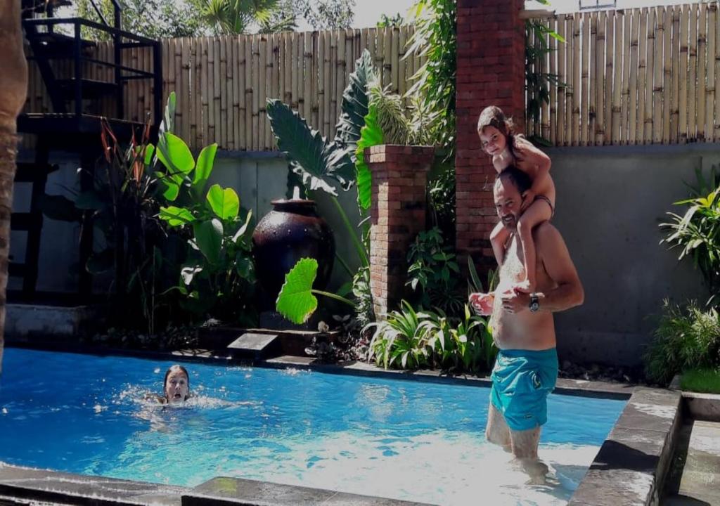 Ein Mann und eine Frau stehen im Pool in der Unterkunft Villa di Amed in Amed