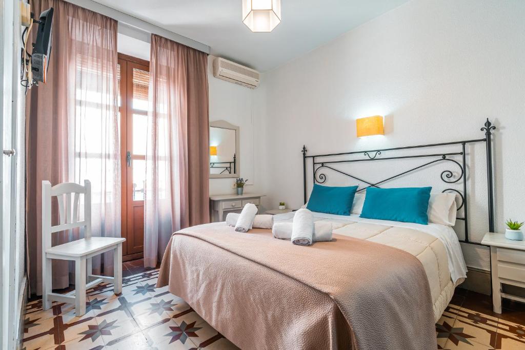 a bedroom with a large bed with blue pillows at Veronica Centro in Granada
