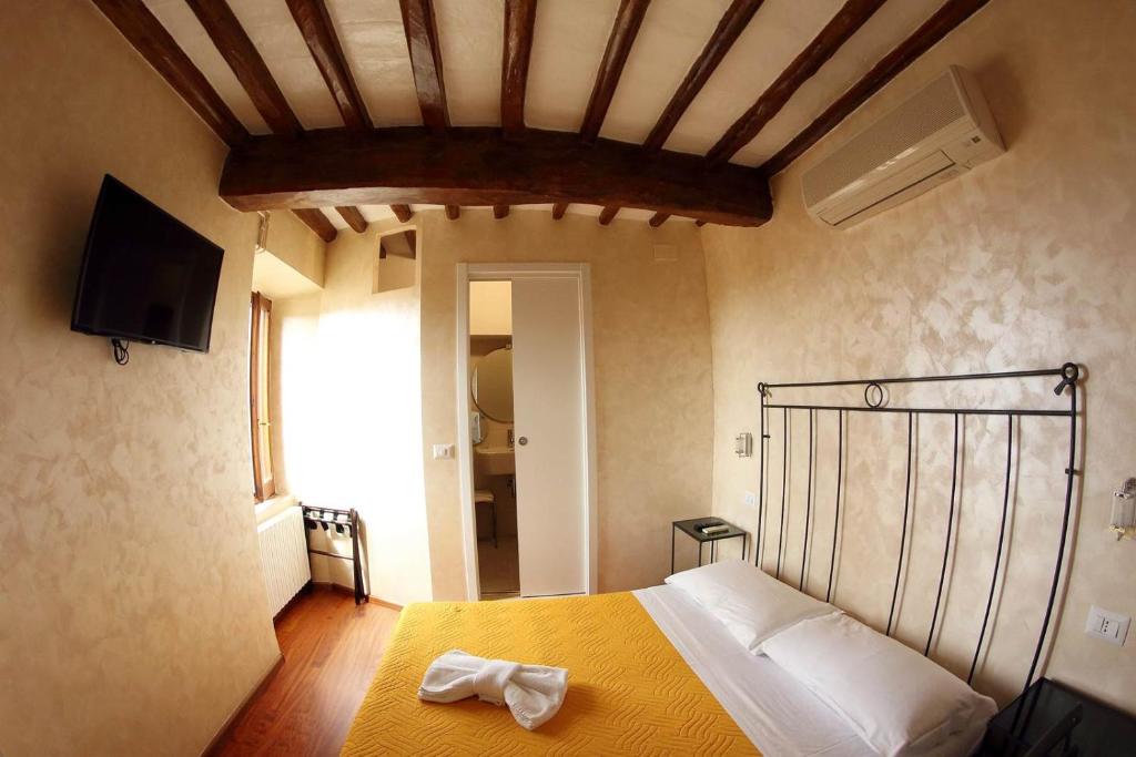 a bedroom with a bed with a yellow bedspread at Primavera Mini Hotel in Perugia