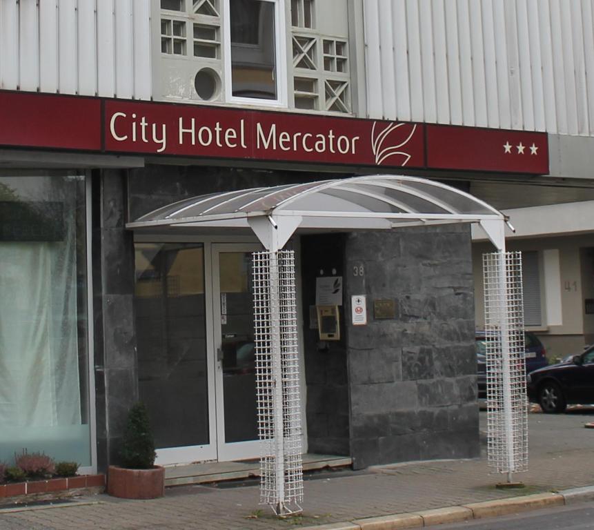 un comerciante de hotel de la ciudad con un paraguas delante de él en City Hotel Mercator en Frankfurt