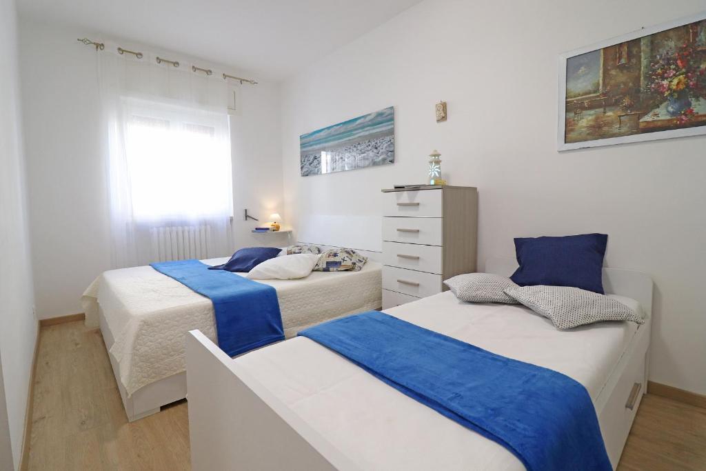 1 Schlafzimmer mit 2 Betten und einer Kommode in der Unterkunft Holiday Apartment With Wi-fi, Air Conditioning And Balcony; Pets Allowed in Otranto