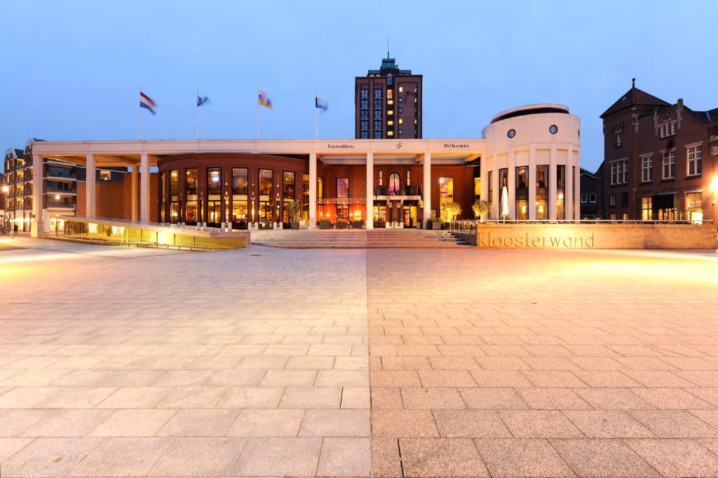 a large building in a city at night at Van der Valk TheaterHotel De Oranjerie in Roermond