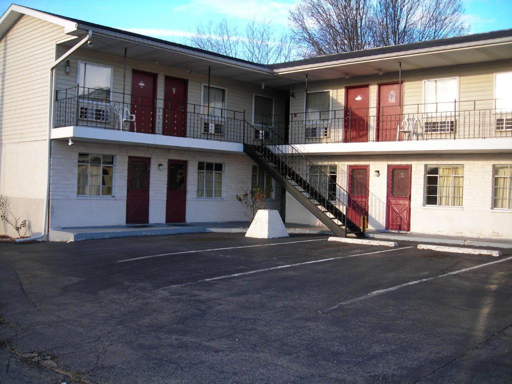a building with red doors and a staircase in a parking lot at Hollywood Motel in Kenova