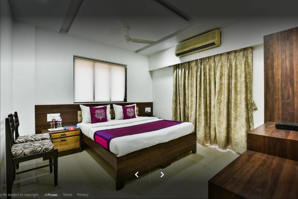 Un dormitorio con una cama y una silla dentro. en Hotel Shelter Palace, en Navi Mumbai