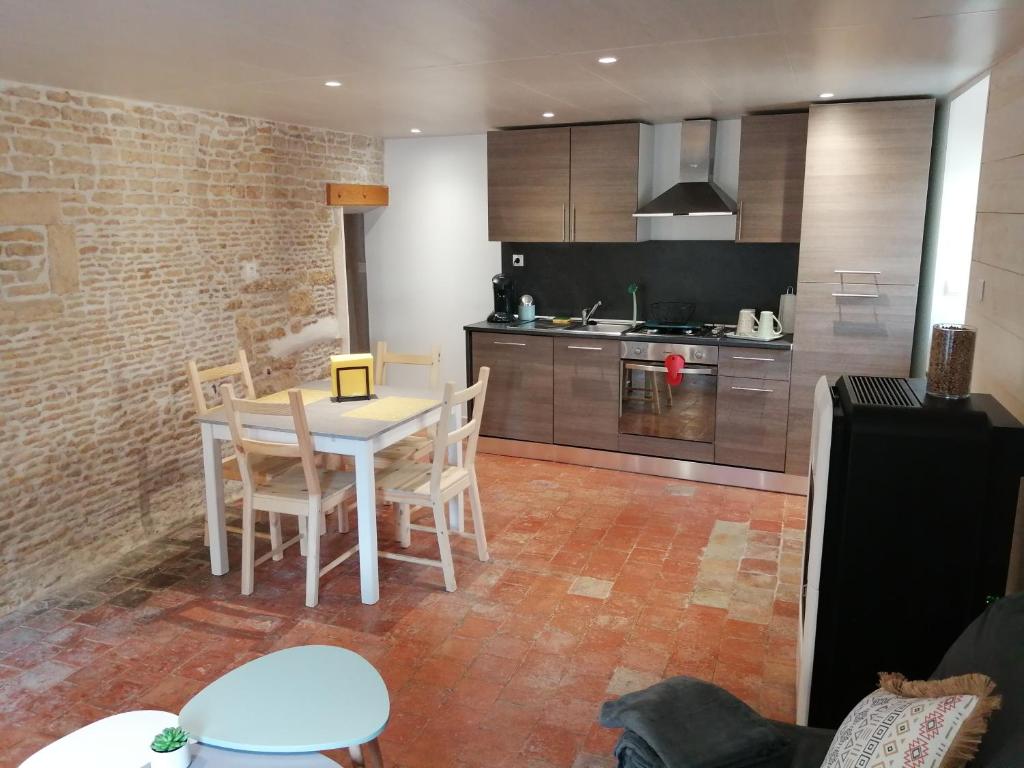 een keuken met een tafel en stoelen in een kamer bij Charmante petite maison de la côte Normande in Courseulles-sur-Mer
