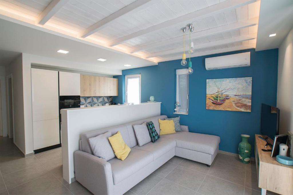 Gianni's house في ماستيخاري: غرفة معيشة مع أريكة وجدران زرقاء