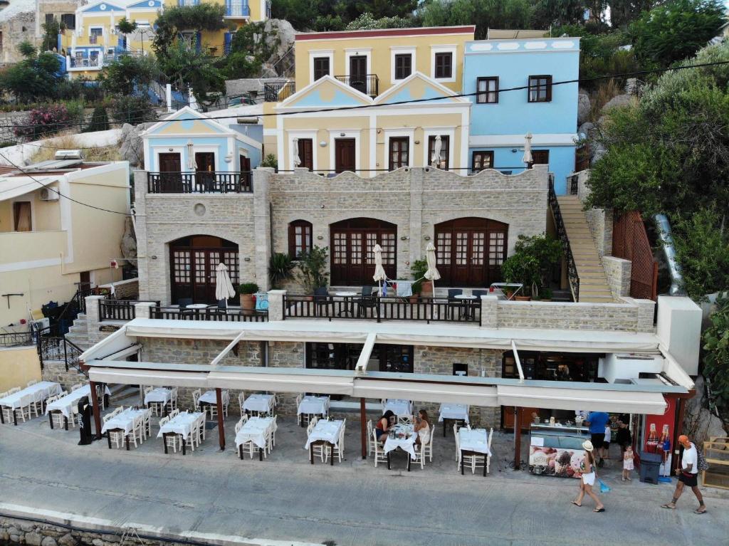 a building with tables and chairs in front of it at Odyssia in Symi