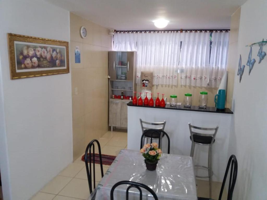 a kitchen with a table with chairs and a counter at Flat Maragogi 3 in Maragogi