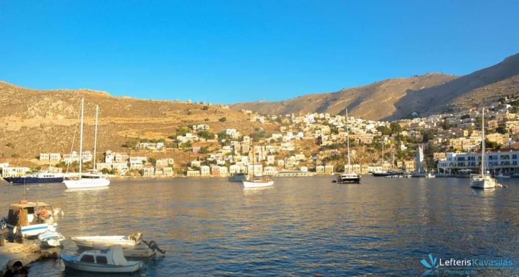 a group of boats docked in a body of water at Odyssia in Symi