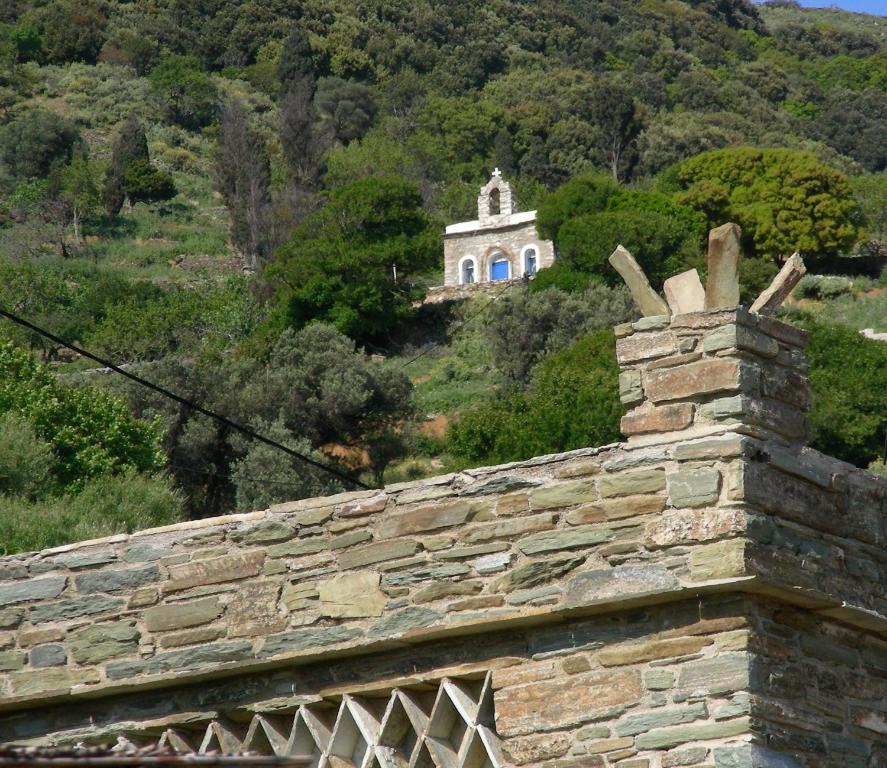 an old stone building with a church in the background at Anastasia Luxury Villas in Gavrio