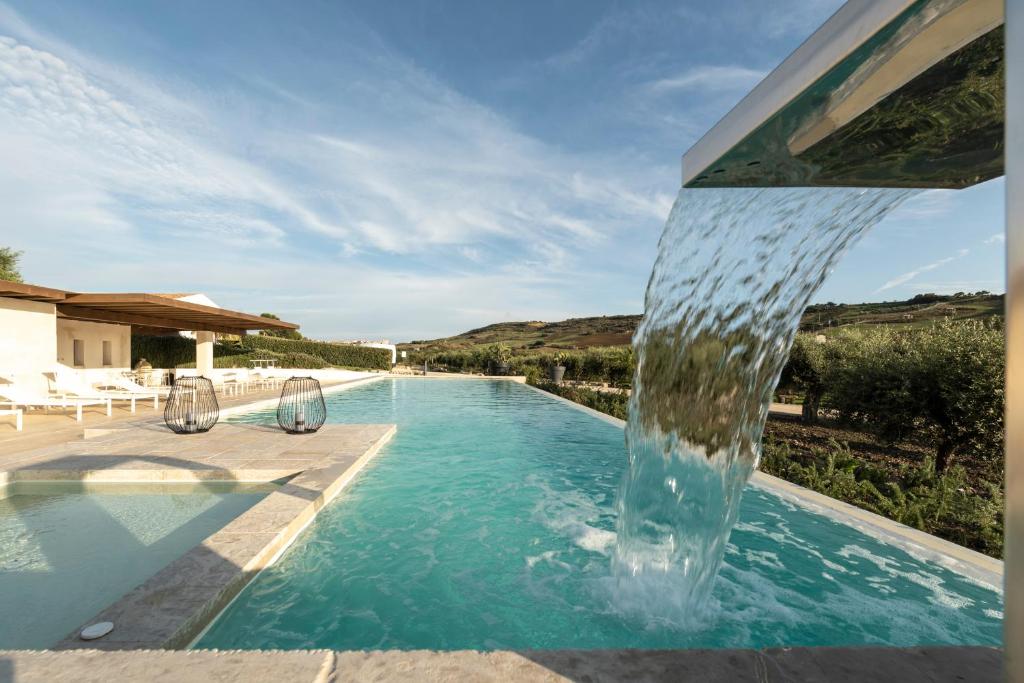 a swimming pool with a water fountain at Borgo Giallonardo Wine Relais in Realmonte