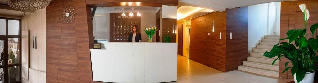 eine Lobby mit einer weißen Theke in einem Gebäude in der Unterkunft Hotel Livia in Wołomin